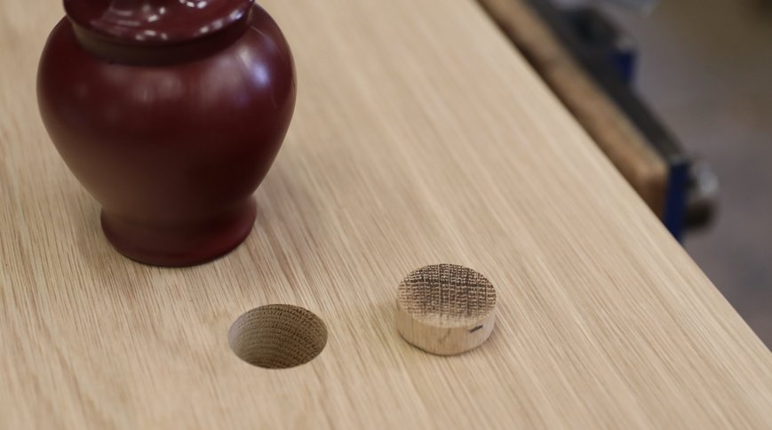 The hollowed-out space and its oak plug, beside the urn