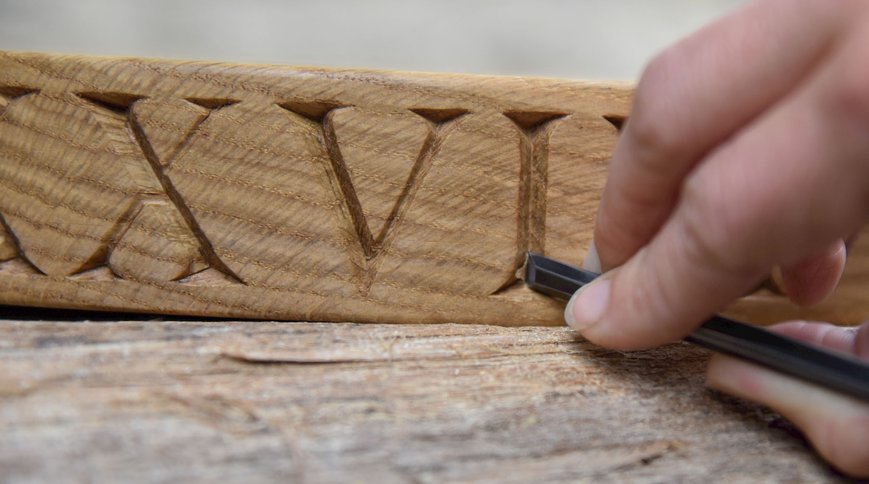 Carving Roman numerals into oak by hand