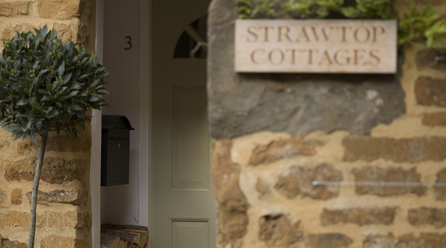 The STRAWTOP COTTAGES sign by the front door. Photo: Sarah Frances Kelley